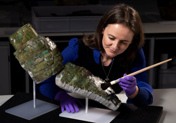 Conservator Bethan Bryan with the brass Roman arm guard