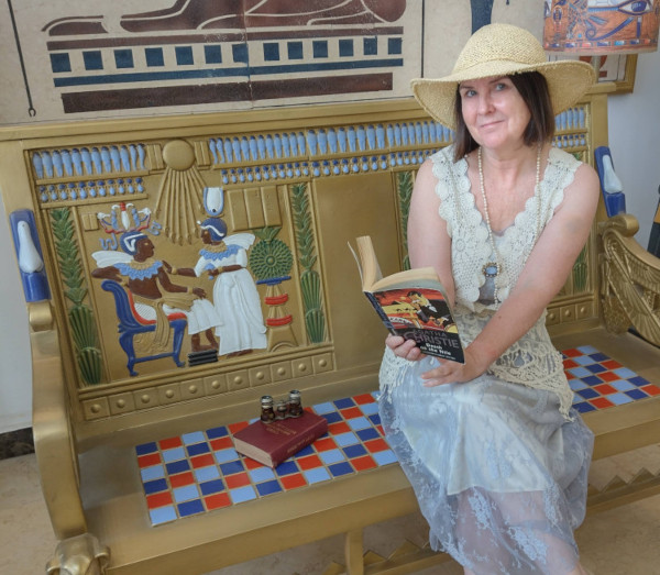 Fiona Veitch Smith reading Agatha Christie's Death on the Nile; a copy of Cook's Travellers' Guide to Egypt and the Sudan is on the seat beside her
