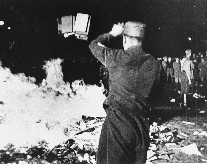 A member of the SA throws confiscated books into the bonfire during the public burning of 'un-German' books on the Opernplatz in Berlin