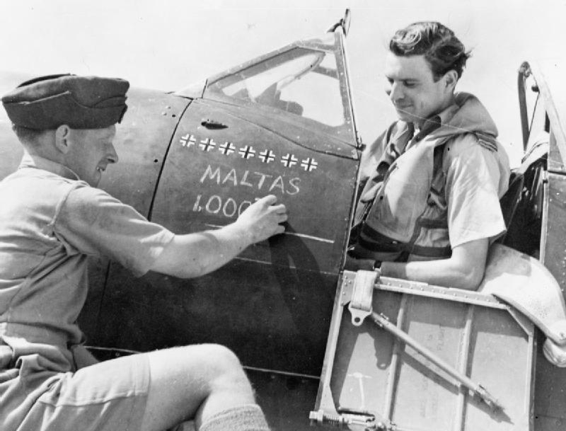 ,An airman chalks "Malta's 1,000th" below the victory tally on Squadron Leader J J Lynch's Supermarine Spitfire Mark VC